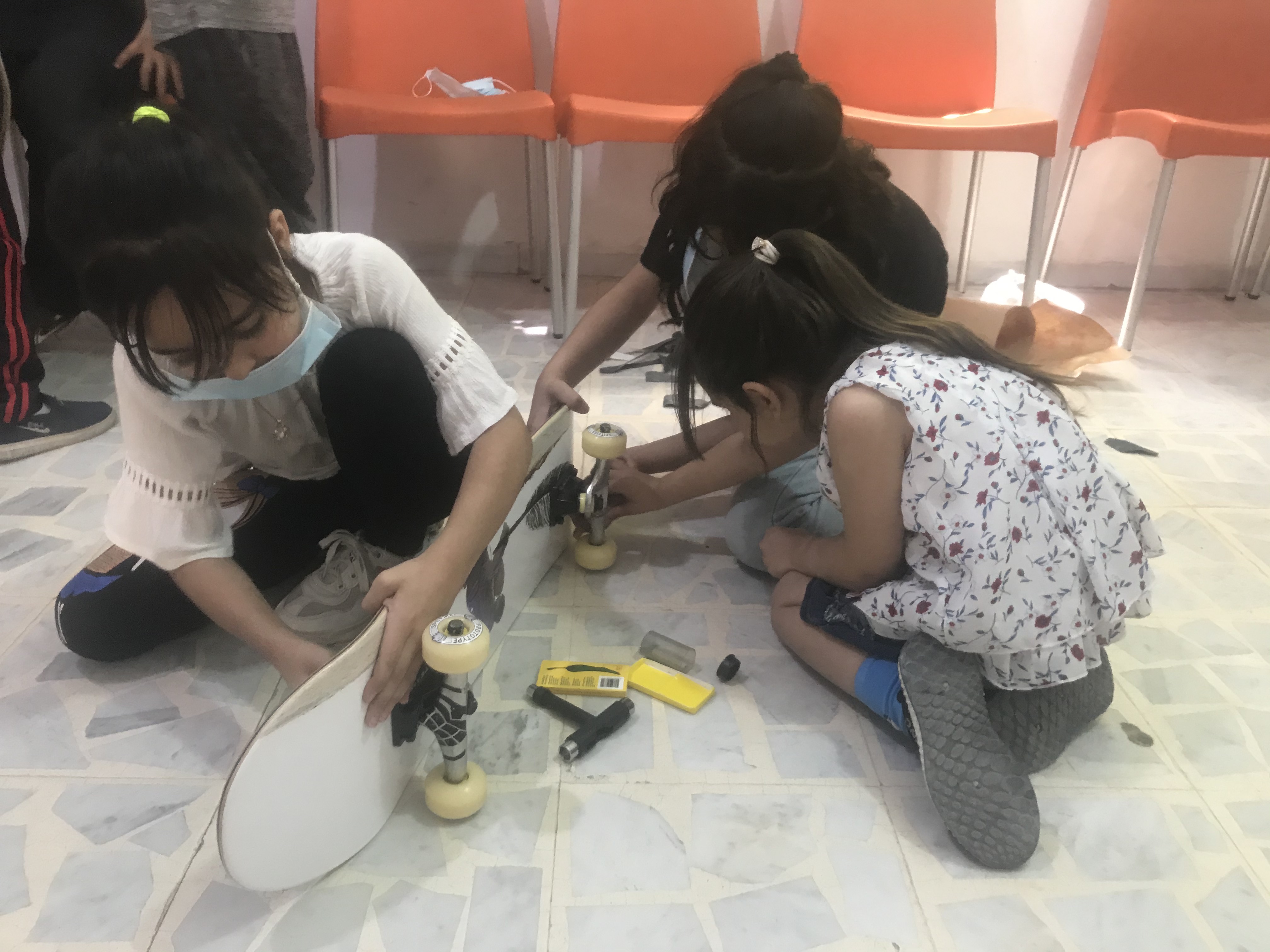 Girls learn how to set up skateboards in Zarqa